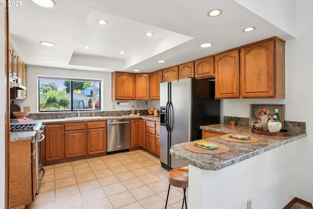 2027 SE Lexington St, Portland, OR 97202 - kitchen with stainless steel appliances, a peninsula, brown cabinetry, recessed lighting, and a breakfast bar