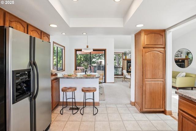 2027 SE Lexington St, Portland, OR 97202 - kitchen featuring stainless steel fridge with ice dispenser, recessed lighting, a peninsula, and brown cabinetry