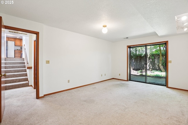 2027 SE Lexington St, Portland, OR 97202 - empty room with light colored carpet, a textured ceiling, and stairs