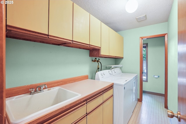 2027 SE Lexington St, Portland, OR 97202 - washroom with cabinet space, washing machine and dryer, a textured ceiling, and light tile patterned floors