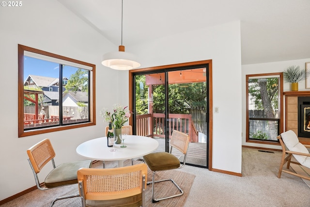 2027 SE Lexington St, Portland, OR 97202 - carpeted dining space featuring healthy amount of natural light, lofted ceiling, and a fireplace