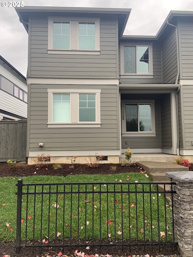view of front of property featuring covered porch, a fenced front yard, and a front lawn