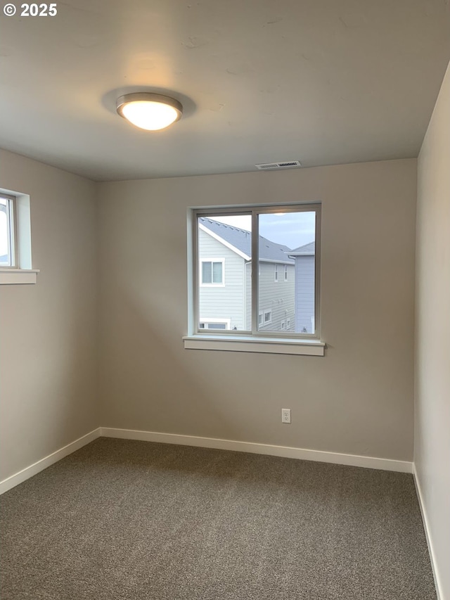 unfurnished room featuring baseboards, carpet floors, and visible vents