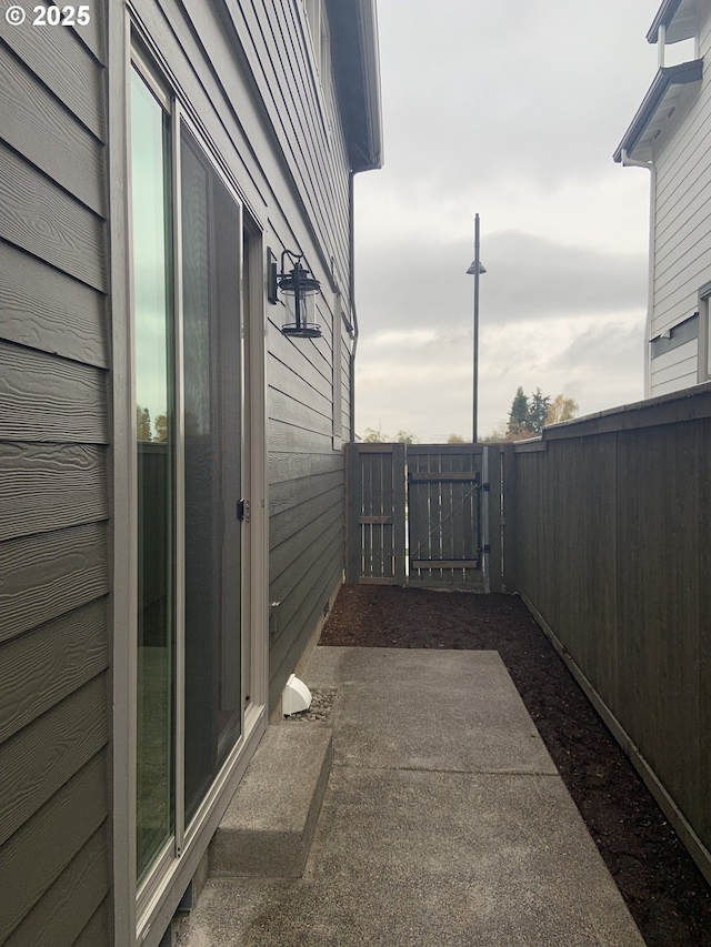view of side of property with fence and a gate