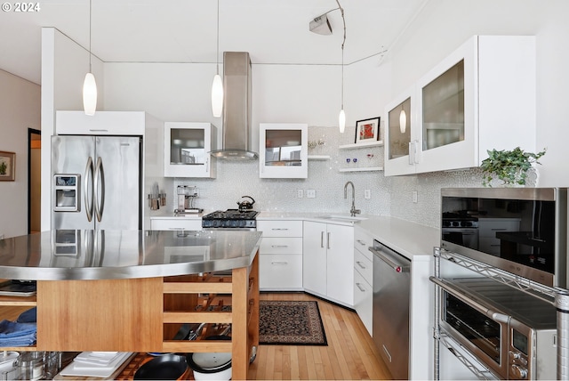 333 NW 9th Ave Unit 1205, Portland, OR 97209 - kitchen featuring appliances with stainless steel finishes, wall chimney range hood, light countertops, a sink, and light wood finished floors