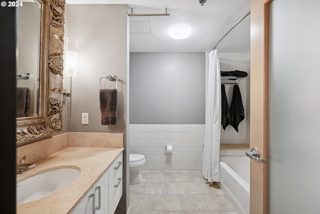333 NW 9th Ave Unit 1205, Portland, OR 97209 - bathroom featuring toilet, vanity, tile walls, tile patterned flooring, and a wainscoted wall