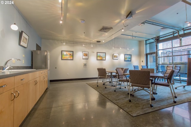 333 NW 9th Ave Unit 1205, Portland, OR 97209 - dining room with track lighting, finished concrete floors, baseboards, and expansive windows