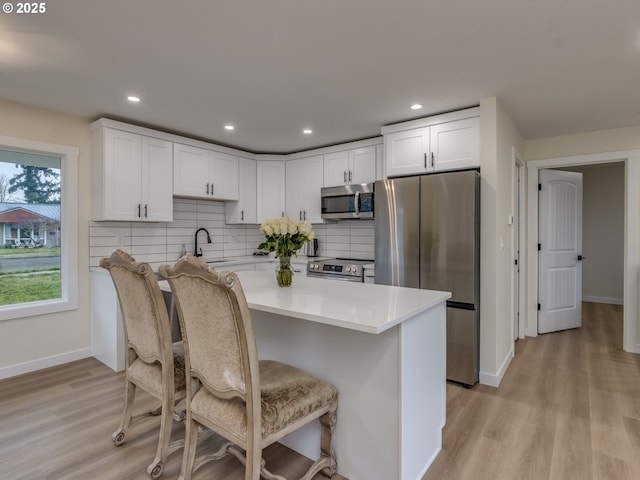 kitchen featuring white cabinets, light wood-type flooring, sink, and stainless steel appliances