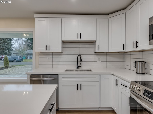 kitchen featuring white cabinets, tasteful backsplash, and sink