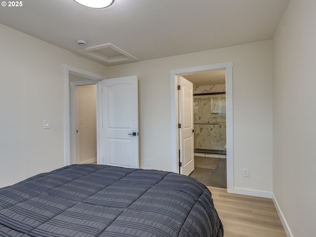 bedroom with ensuite bathroom and light hardwood / wood-style flooring