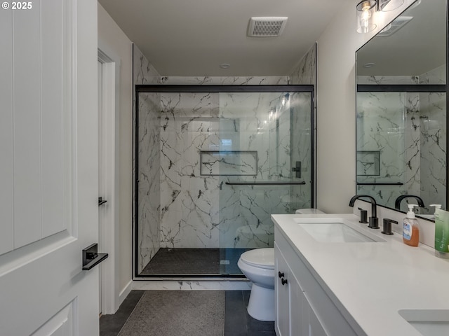 bathroom featuring toilet, vanity, and a shower with door