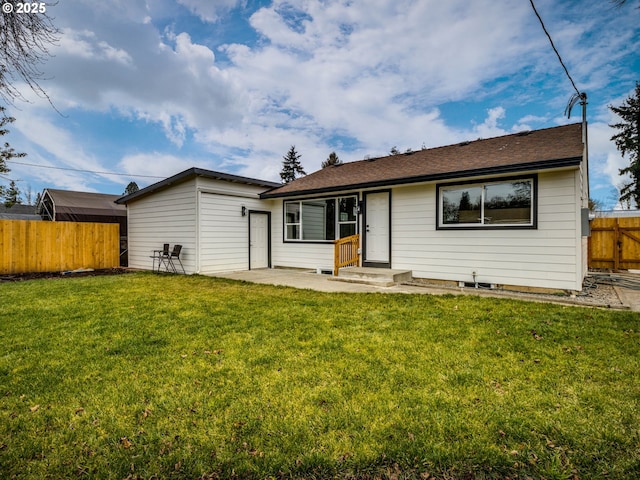 rear view of property featuring a yard and a patio