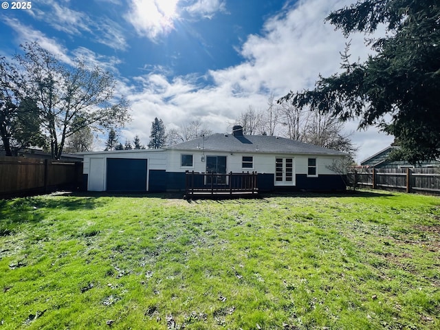 back of property featuring a garage, a yard, and a fenced backyard