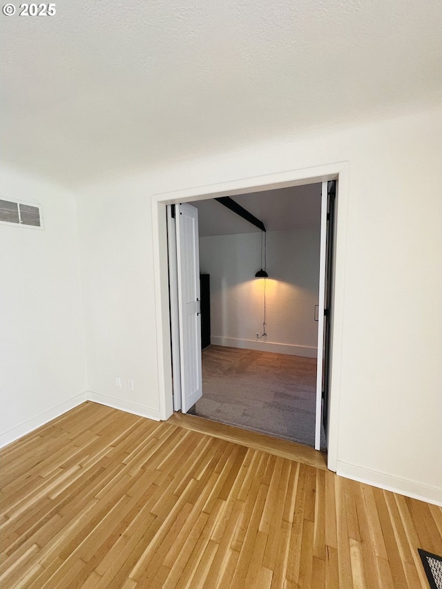 unfurnished room featuring visible vents, baseboards, and light wood-style flooring