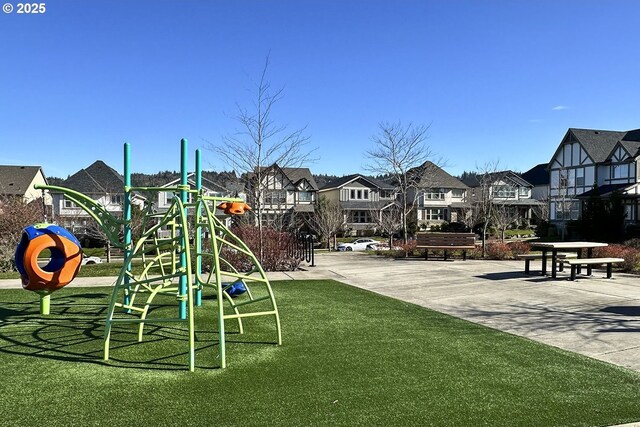 community playground featuring a residential view and a yard