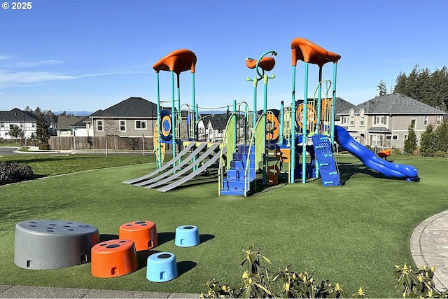 community playground featuring a lawn, fence, and a residential view