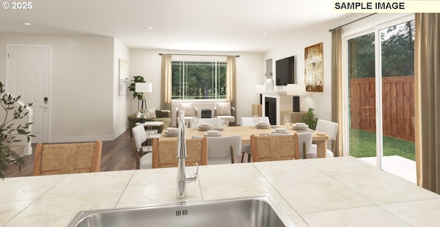 dining room featuring recessed lighting, a fireplace, baseboards, and wood finished floors