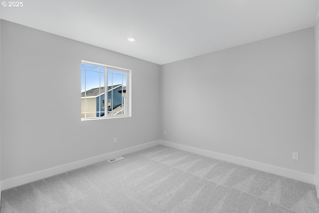 carpeted empty room featuring baseboards, visible vents, and recessed lighting