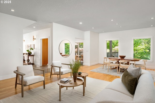 living area featuring healthy amount of natural light, recessed lighting, light wood-type flooring, and baseboards