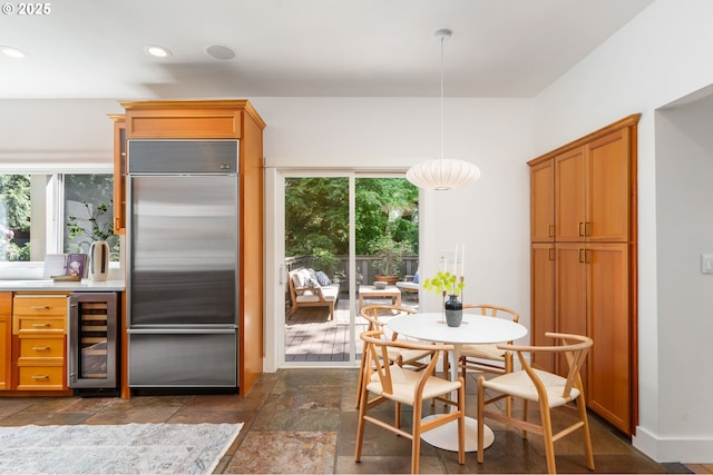 dining area featuring beverage cooler, stone tile floors, and recessed lighting