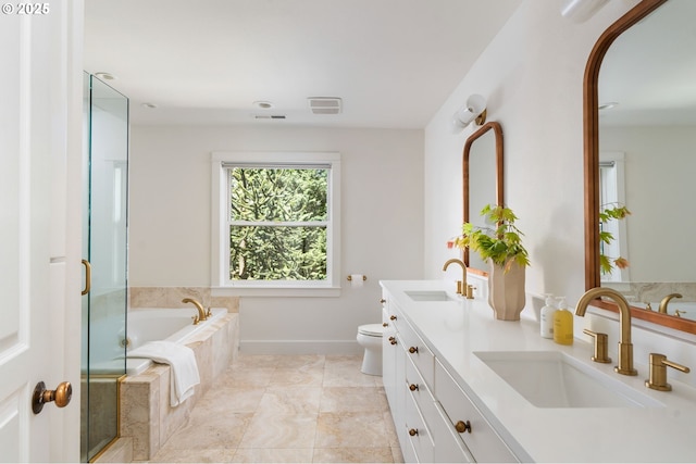 bathroom with a garden tub, double vanity, toilet, a shower with door, and baseboards