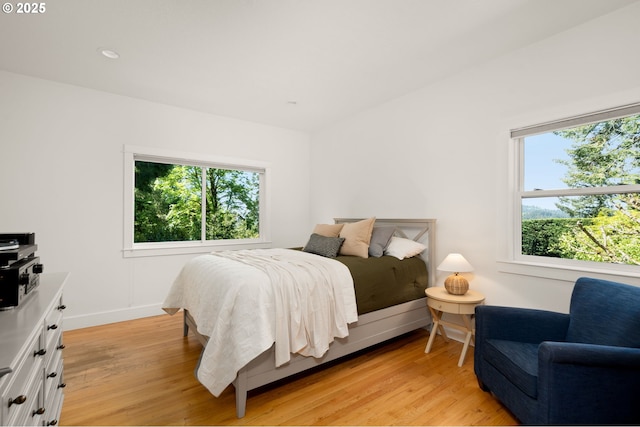 bedroom with light wood-type flooring and baseboards