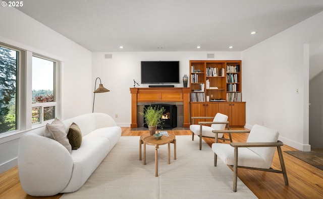 living area featuring light wood-type flooring, baseboards, and recessed lighting