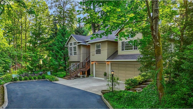 7445 SW Canyon Dr, Portland, OR 97225 - view of front facade featuring driveway, an attached garage, stairway, and a shingled roof