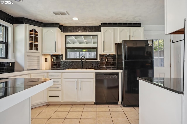 kitchen with light tile patterned floors, white cabinetry, tasteful backsplash, a sink, and black appliances