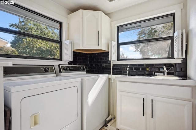 laundry room with a healthy amount of sunlight, a sink, cabinet space, and washing machine and dryer