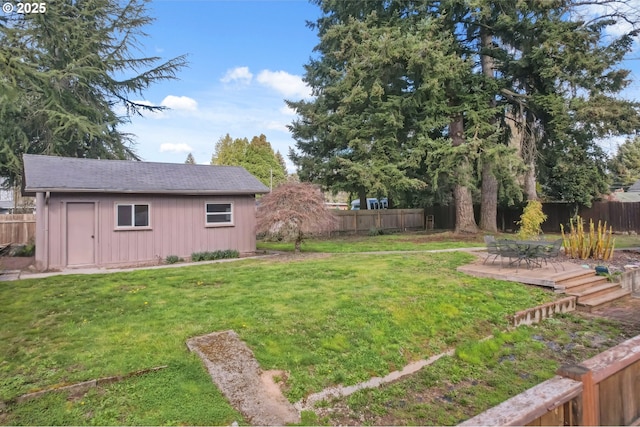 view of yard with a patio area, an outbuilding, and a fenced backyard