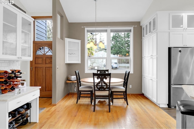 dining space featuring light wood-style floors, plenty of natural light, and baseboards