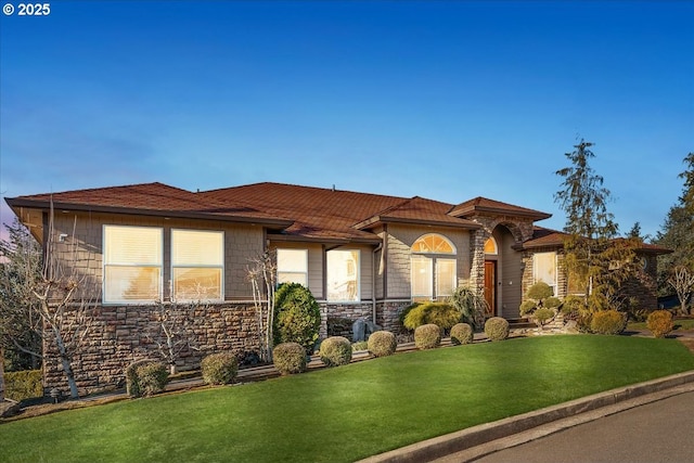 view of front of home featuring a front yard and stone siding