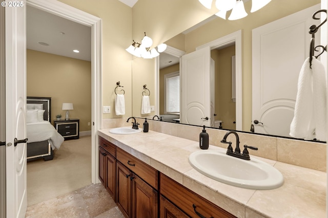 full bathroom with double vanity, ceiling fan, a sink, and ensuite bathroom