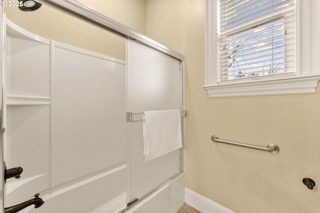 bathroom with baseboards and enclosed tub / shower combo