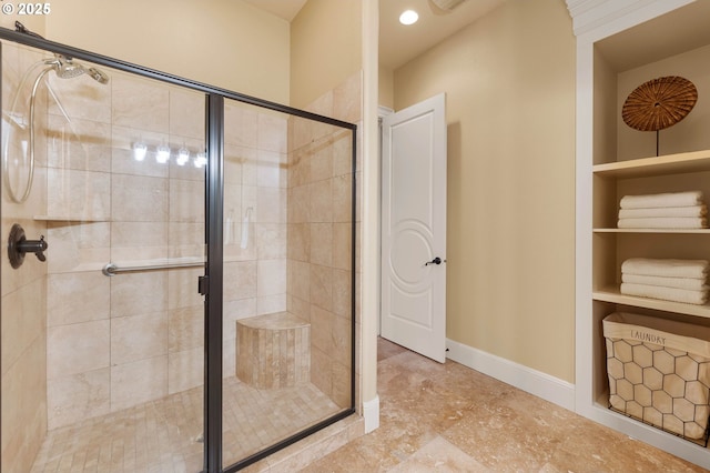 bathroom featuring built in features, baseboards, and a stall shower