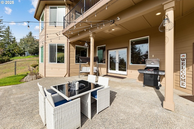 view of patio featuring outdoor dining area, grilling area, fence, and french doors