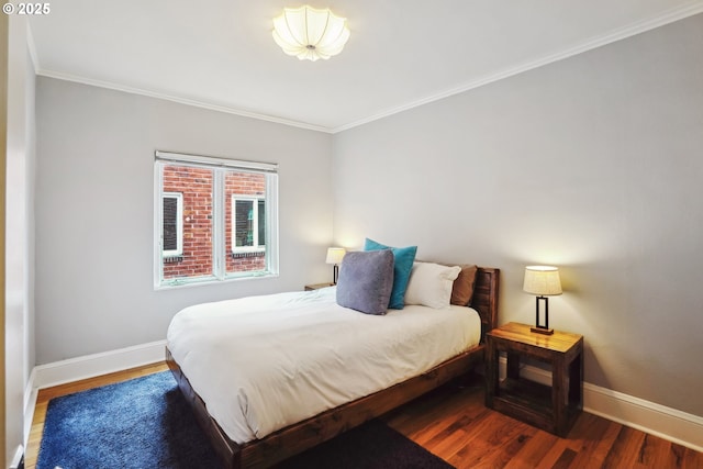 bedroom featuring crown molding, wood finished floors, and baseboards