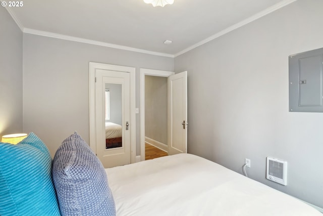 bedroom with electric panel, crown molding, and wood finished floors