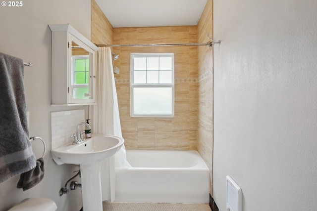 bathroom with backsplash and shower / bath combination with curtain