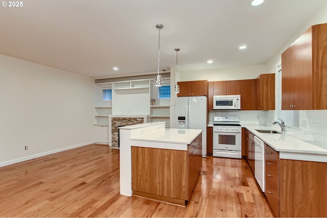 8006 SE Sporri Ln, Milwaukie, OR 97267 - kitchen with white appliances, brown cabinetry, light wood-type flooring, a center island, and recessed lighting