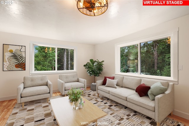 living area featuring a healthy amount of sunlight, baseboards, and wood finished floors