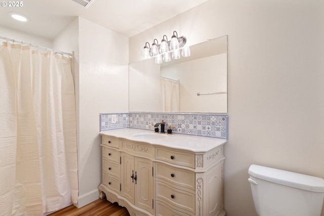 full bath featuring vanity, toilet, recessed lighting, decorative backsplash, and wood finished floors