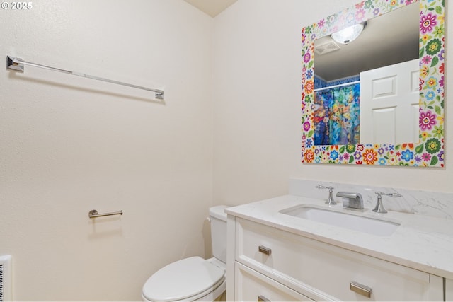 bathroom with visible vents, vanity, and toilet