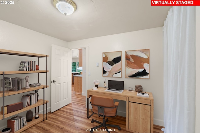 office featuring baseboards and light wood-style flooring