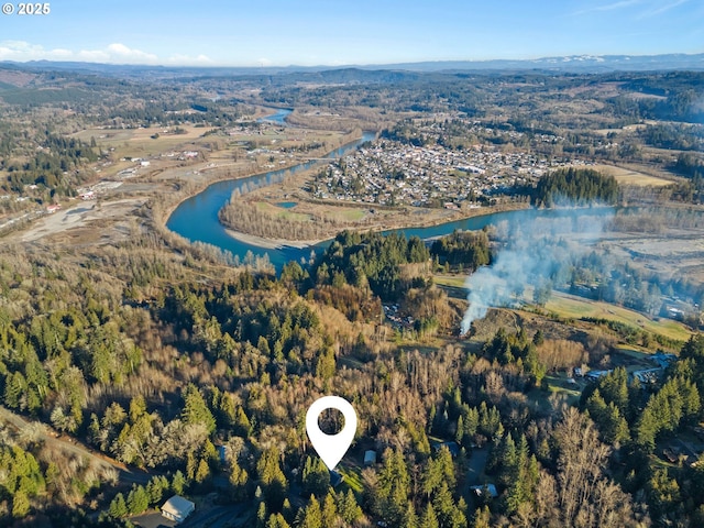 drone / aerial view featuring a water view and a wooded view