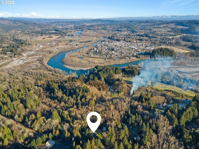 aerial view with a water and mountain view and a forest view