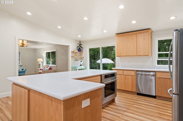 kitchen with light wood finished floors, stainless steel appliances, light brown cabinetry, and plenty of natural light