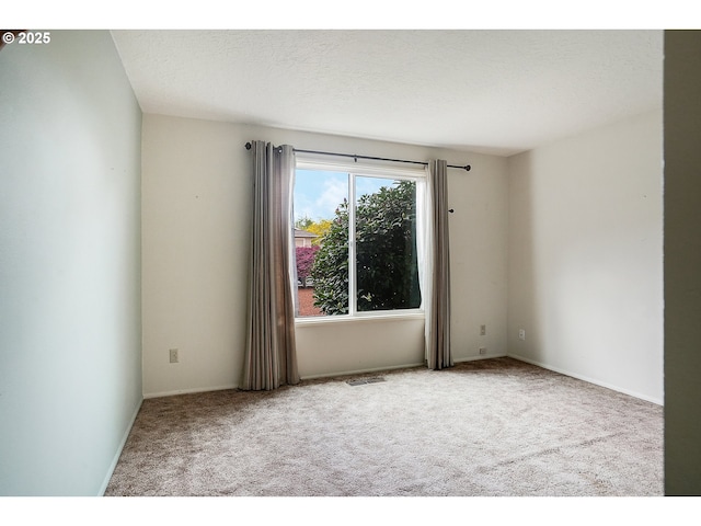 unfurnished room featuring carpet flooring and visible vents