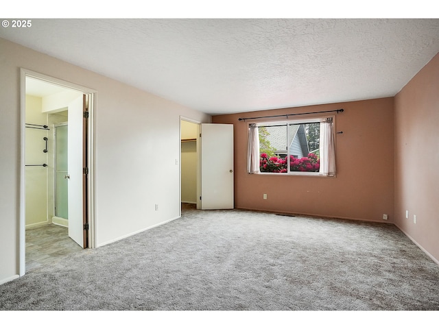 unfurnished bedroom featuring carpet floors, baseboards, and ensuite bath